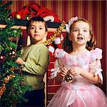 two beautiful happy child decorate christmas tree