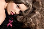 close-up portrait of pretty girl with gloss wavy hair on dark cloth, she looks in to the lens with sensual eyes