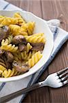 Dish of pasta with mushroom on wood table