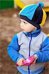 little boy playing in the sandbox at autumn