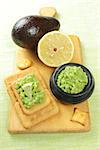 healthy snack of crackers and mashed avocado