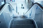 Escalator in airport. Tilt shift lens used to accent the stairs and sublime blue cast applied for more business effect