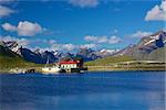 Scenic panorama on Lofoten islands in Norway with traditional norwegian fishing boat and high mountain peaks