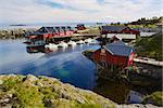 Typical red rorbu fishing huts on Lofoten islands in Norway reflecting in fjord