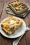 Dish of Lasagna with artichokes on wood table