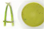 Asparagus soup in a bowl on a blurry background