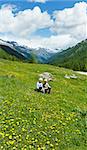 Children on summer mountain meadow with yellow dandelion flowers (Alps, Switzerland)