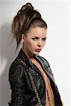 sexy and dark lady with black leather jacket and pants with hair style looking in camera