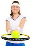 Closeup on ball on racket in hand of female tennis player