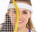 Portrait of female tennis player with racket in front of face