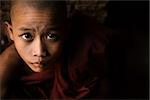 Portrait of a little monk, low light inside temple