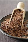 Close-up of Flax Seeds in Bowl with Scoop, Studio Shot