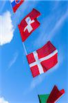 Slovakian, Swiss, and Danish flags against blue summer sky