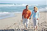 Mature Couple Walking on Beach and Holding Hands, USA