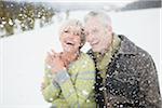 Selective focus portrait of couple laughing in the snow.