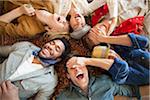 group of young adults laying down looking up laughing