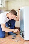 Repairman working on appliance in kitchen