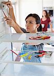 Female repair person working on fridge in home