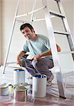 Man examining paint cans in room