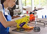 Maid cleaning stove top