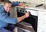 Electrician working on oven in kitchen
