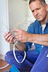 Electrician examining wires in kitchen