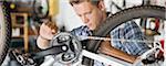 Man working on bicycle in shop