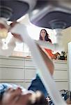 Woman watching plumber work on pipes