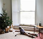 Boy playing with train by Christmas tree