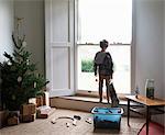 Boy holding Christmas stocking at window