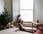 Children relaxing by Christmas tree