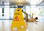 Businessman slipping on wet office floor