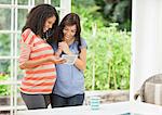 Pregnant woman showing friend sonogram