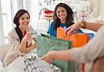 Woman showing friends shopping bags