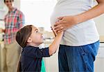 Girl holding pregnant mother's belly