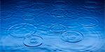 Ripples of raindrops in puddle