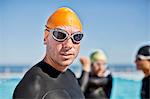 Triathletes in wetsuits wearing goggles and cap