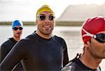 Triathletes in wetsuit smiling in water