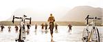 Triathletes running to bicycles on beach