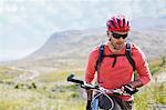 Man walking bicycle in rural landscape