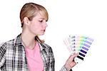 young female painter holding color chart