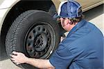 Auto mechanic removing the tire from a car.