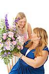 Beautiful blond teenage girl giving flowers to he mother.   Mothers Day concept.  Isolated on white.