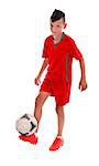 Young kid in red uniform  playing football - studio shot