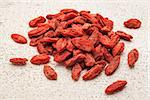 a pile of Tibetan goji berries on a rough white painted barn wood