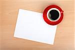 Blank paper and red coffee cup on wood table