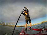 mature male paddler enjoying workout on stand up paddleboard (SUB), calm lake in Colorado, early spring