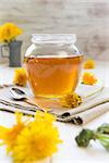 Jar with Syrup of Dandelion's flowers on table