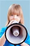 boy with long blond hair playing with megaphone - isolated on blue