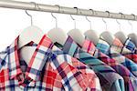 Mens colorful checked shirts on white hangers, close-up, shallow dof, white background